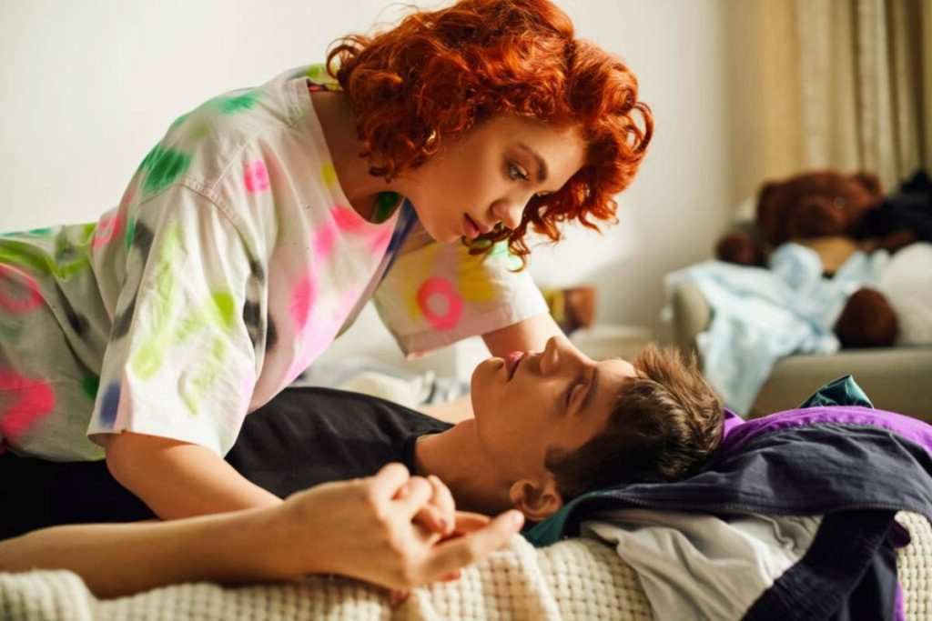 A man lies in bed with a woman after making up